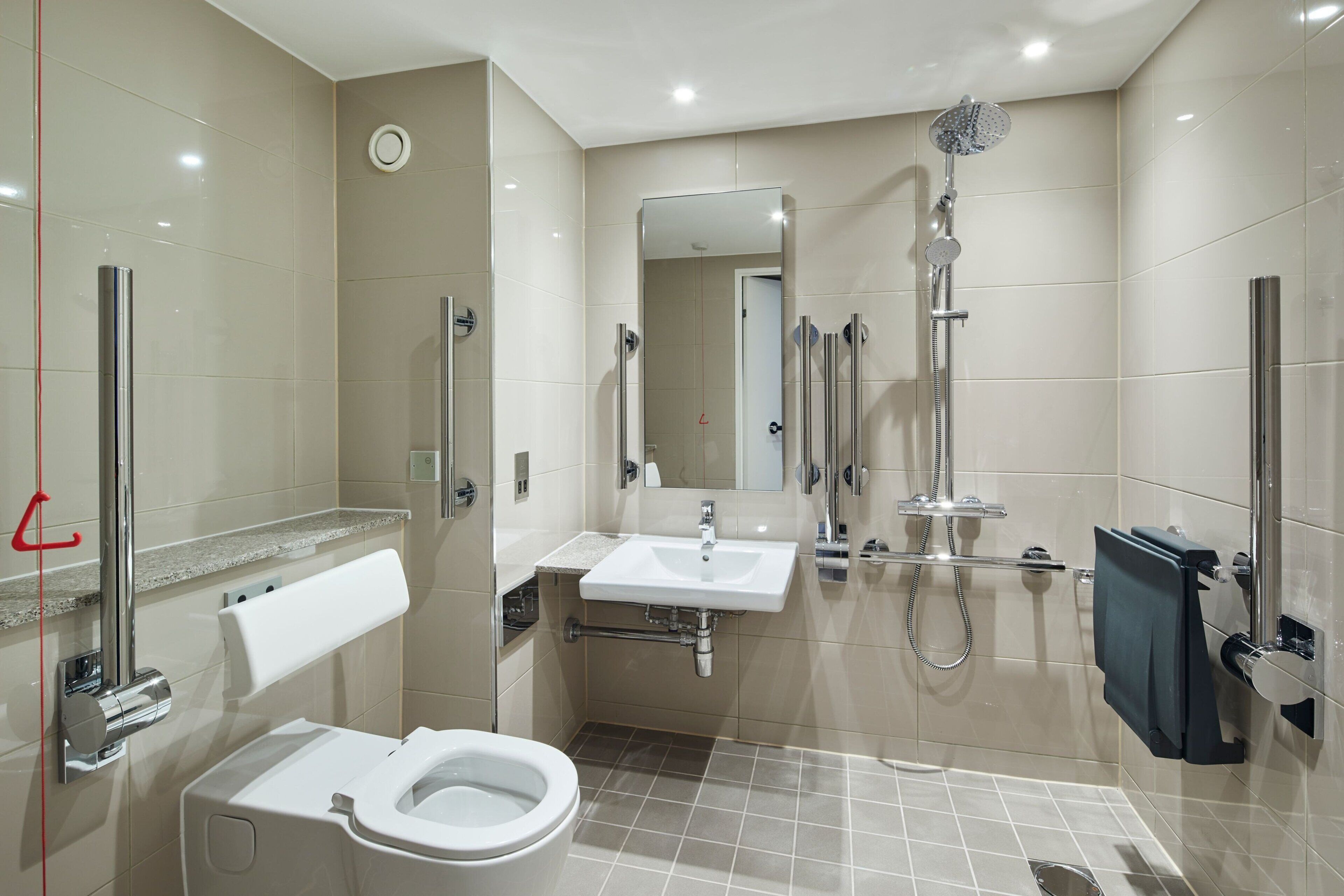 Une salle de bain moderne équipée de toilettes, d’un lavabo et d’une douche.
