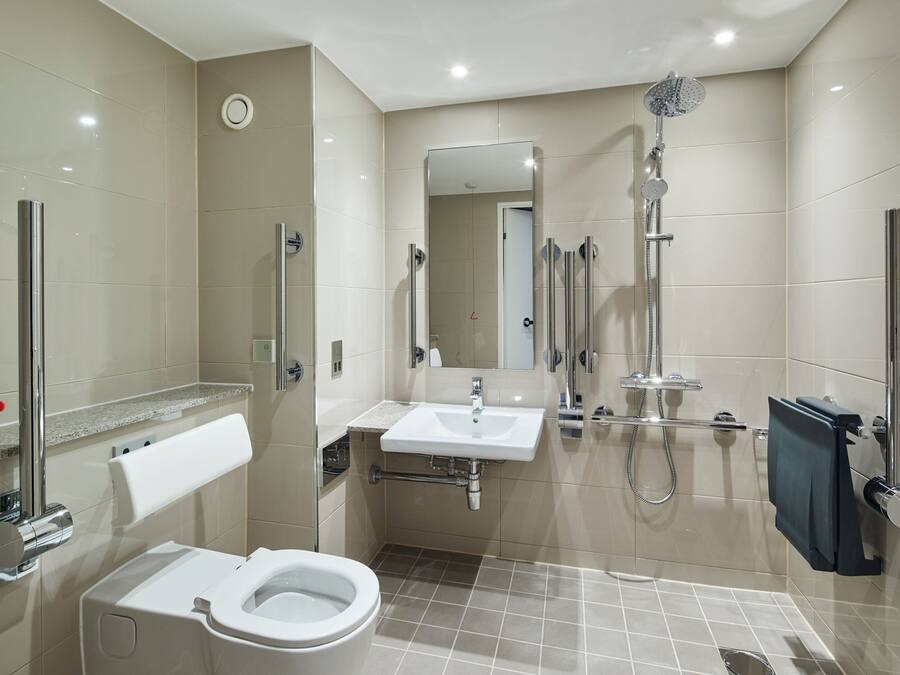 Une salle de bain moderne équipée de toilettes, d’un lavabo et d’une douche.