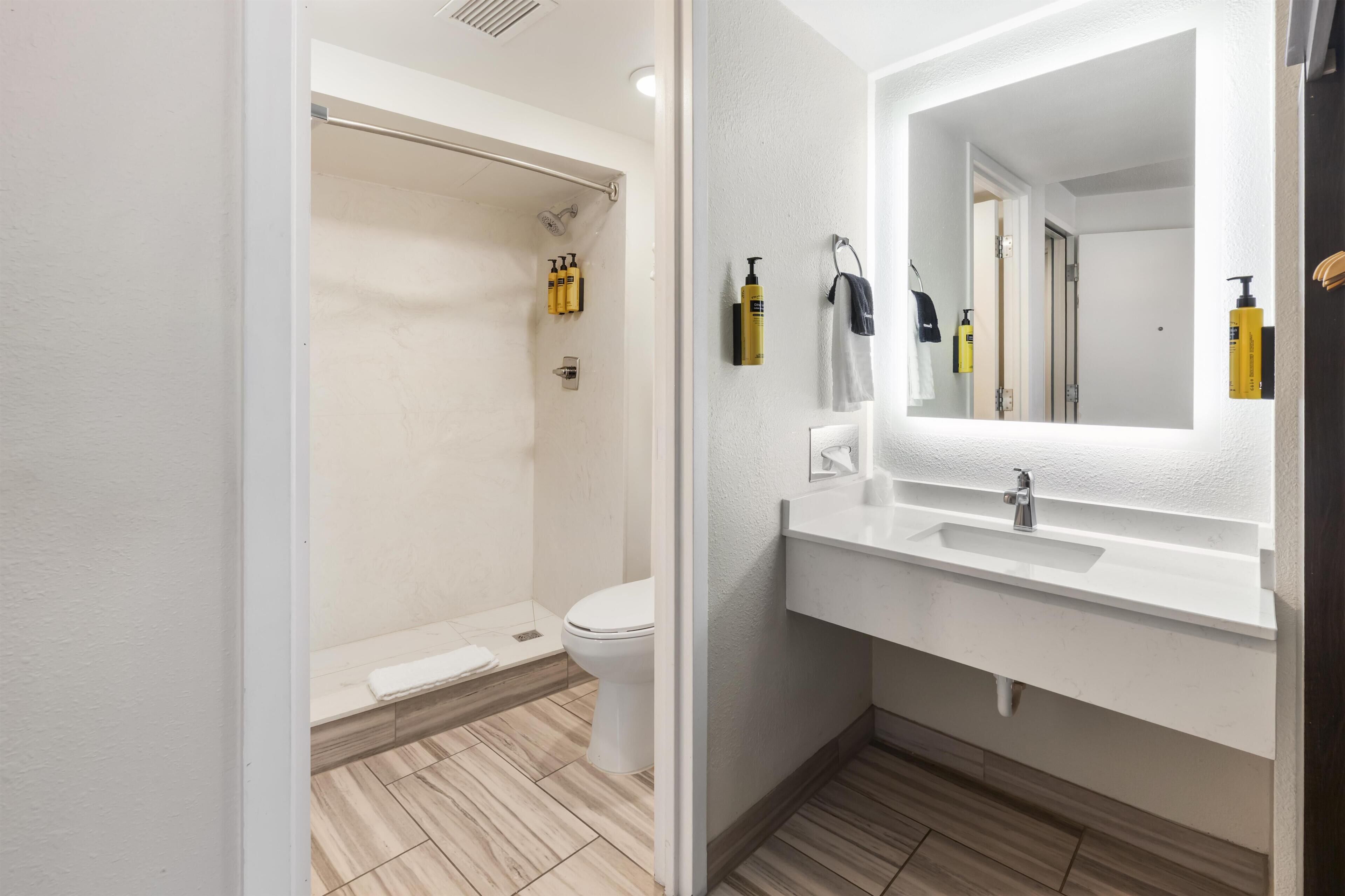Un bagno moderno con doccia, WC e lavabo con specchio.