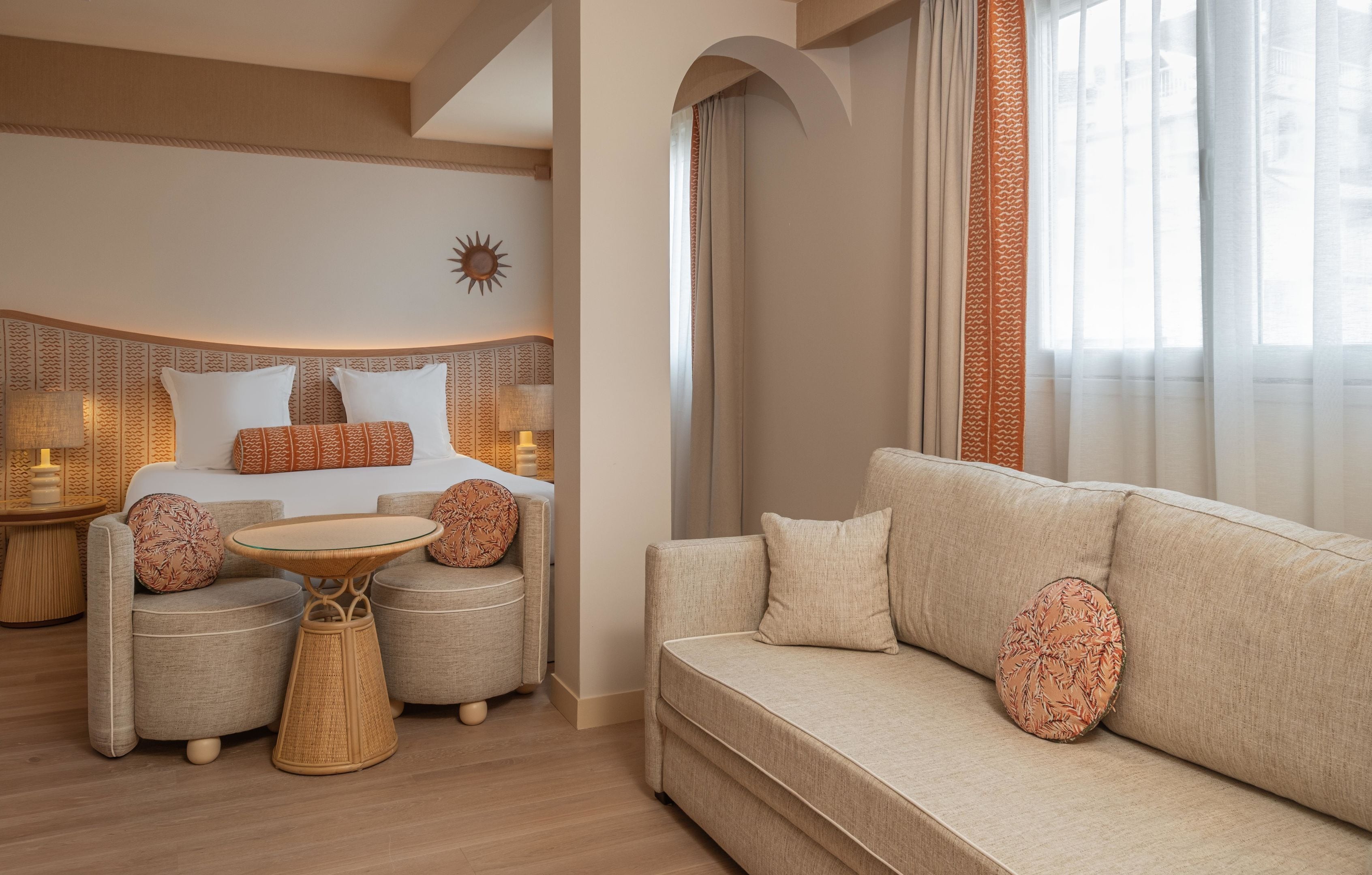 Une chambre d’hôtel avec un lit, un canapé, une petite table et un mur décoratif.
