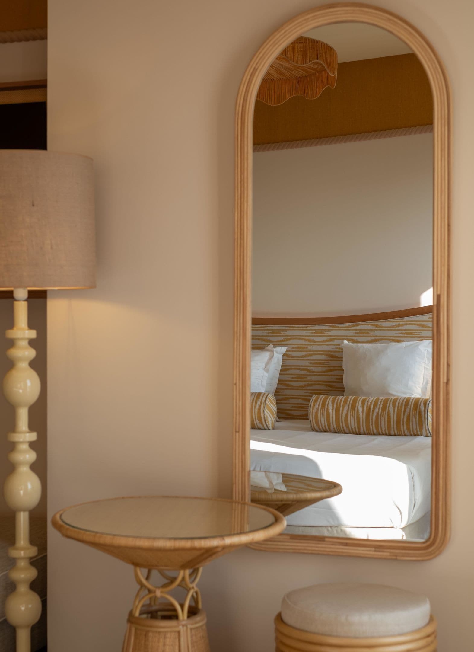 Una habitación con una cama, una mesa redonda y un espejo en la pared.