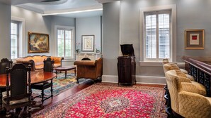 A spacious living room with a fireplace, a large rug, and a seating area with a sofa and chairs. - New Orleans Courtyard Hotel and Suites by the French Quarter (New Orleans)