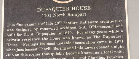 A plaque describing the Dupaquier House at 1101 North Rampart, highlighting its late 19th-century Italianate architecture and its history as a jazz club.