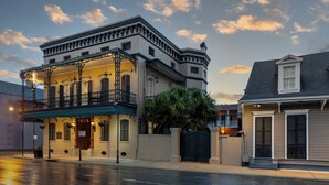 A historic building with a balcony, a gated entrance, and a neighboring house. - New Orleans Courtyard Hotel and Suites by the French Quarter (New Orleans)