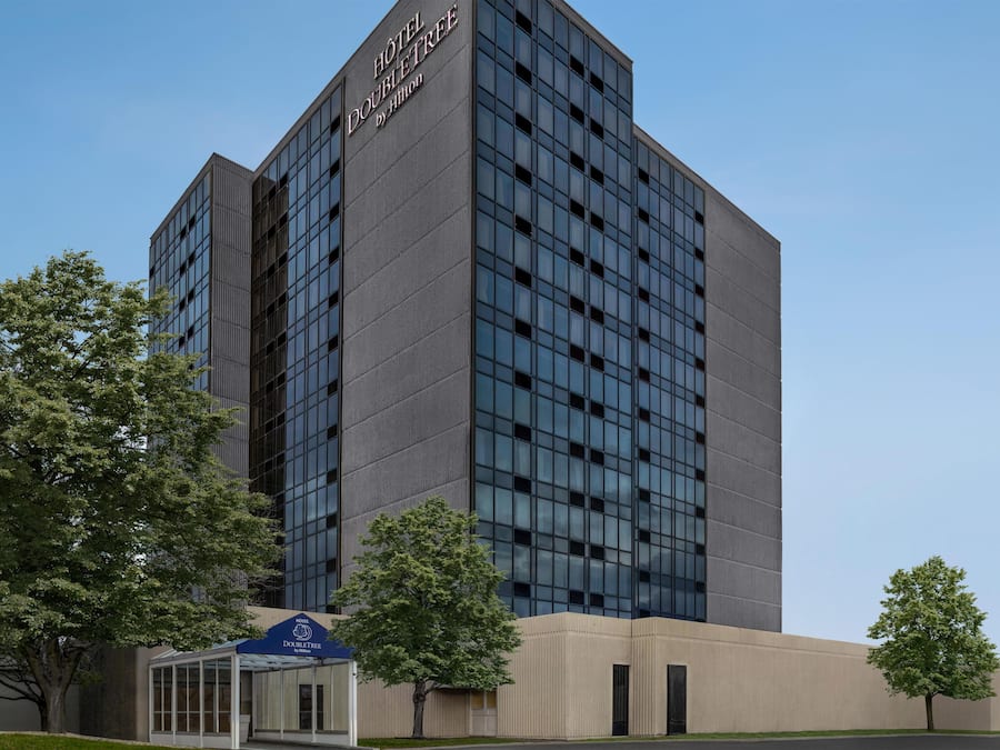 Een modern hotelgebouw met een opvallend bord waarop 'HOTEL DOUBLETREE by Hilton' staat.