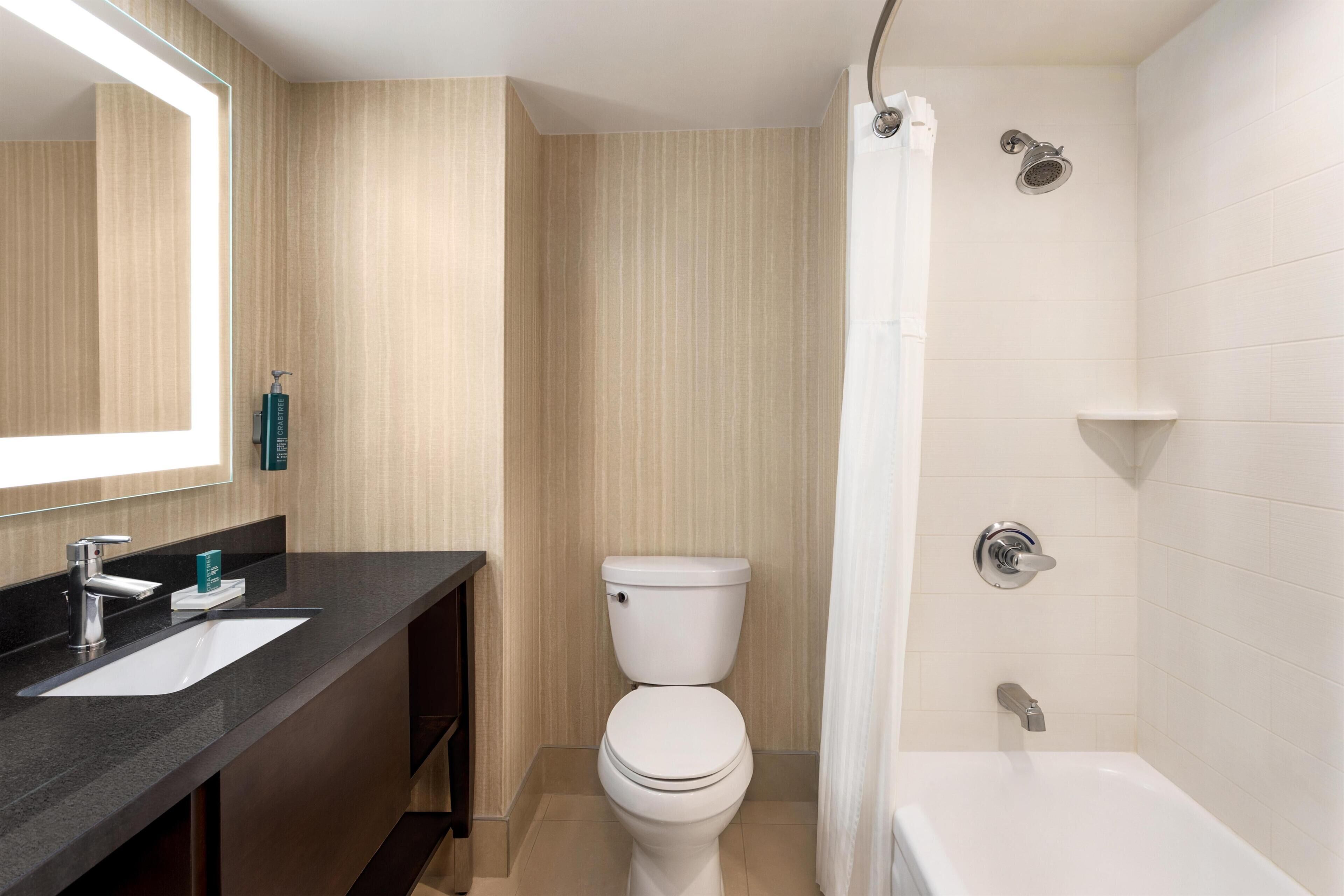 A modern bathroom with a sink, toilet, and shower.