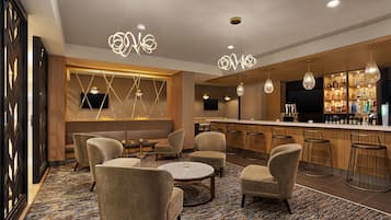 A bar area with seating, a bar counter, and overhead lighting.