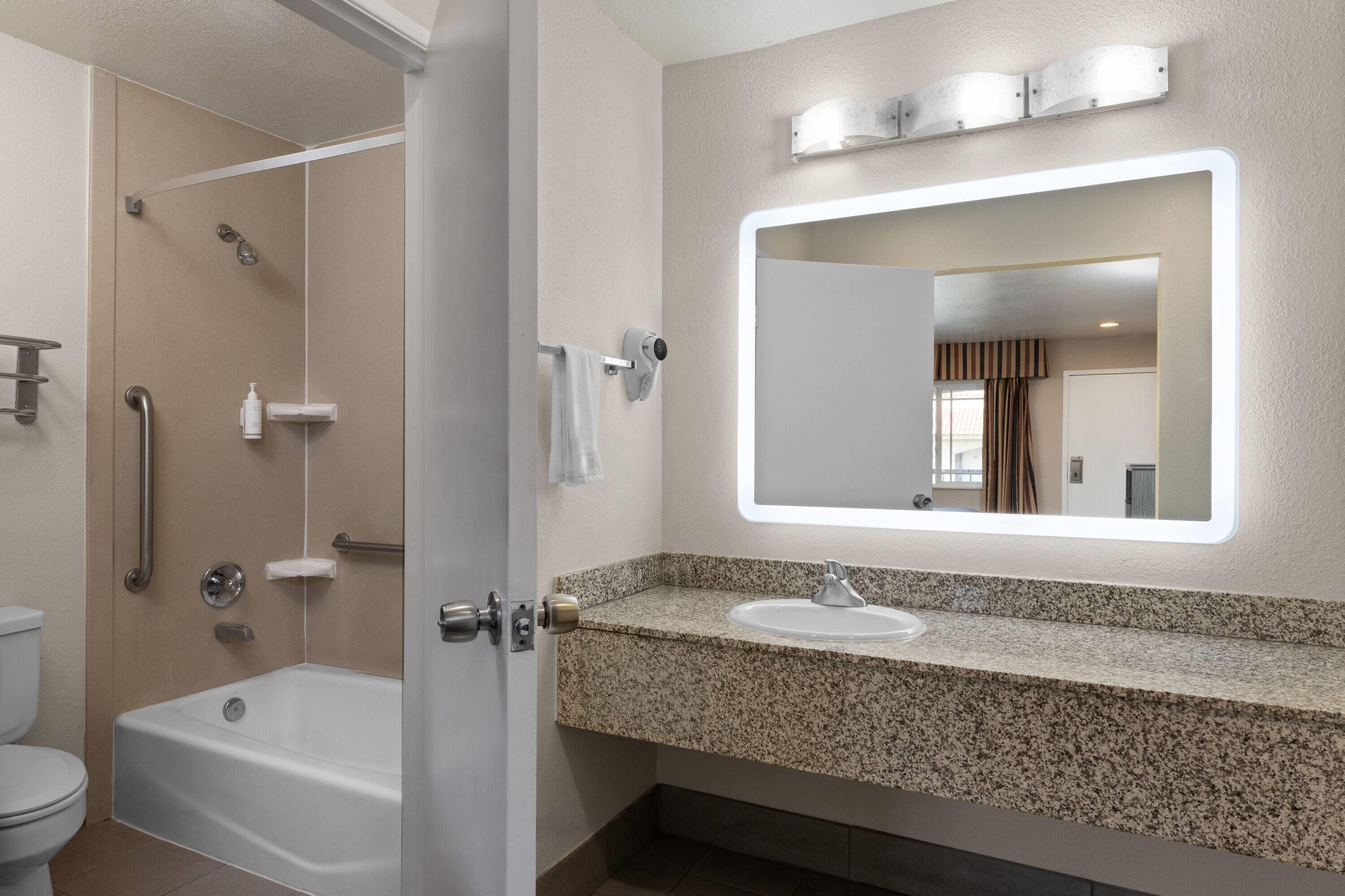 A modern bathroom with a shower, toilet, and sink.