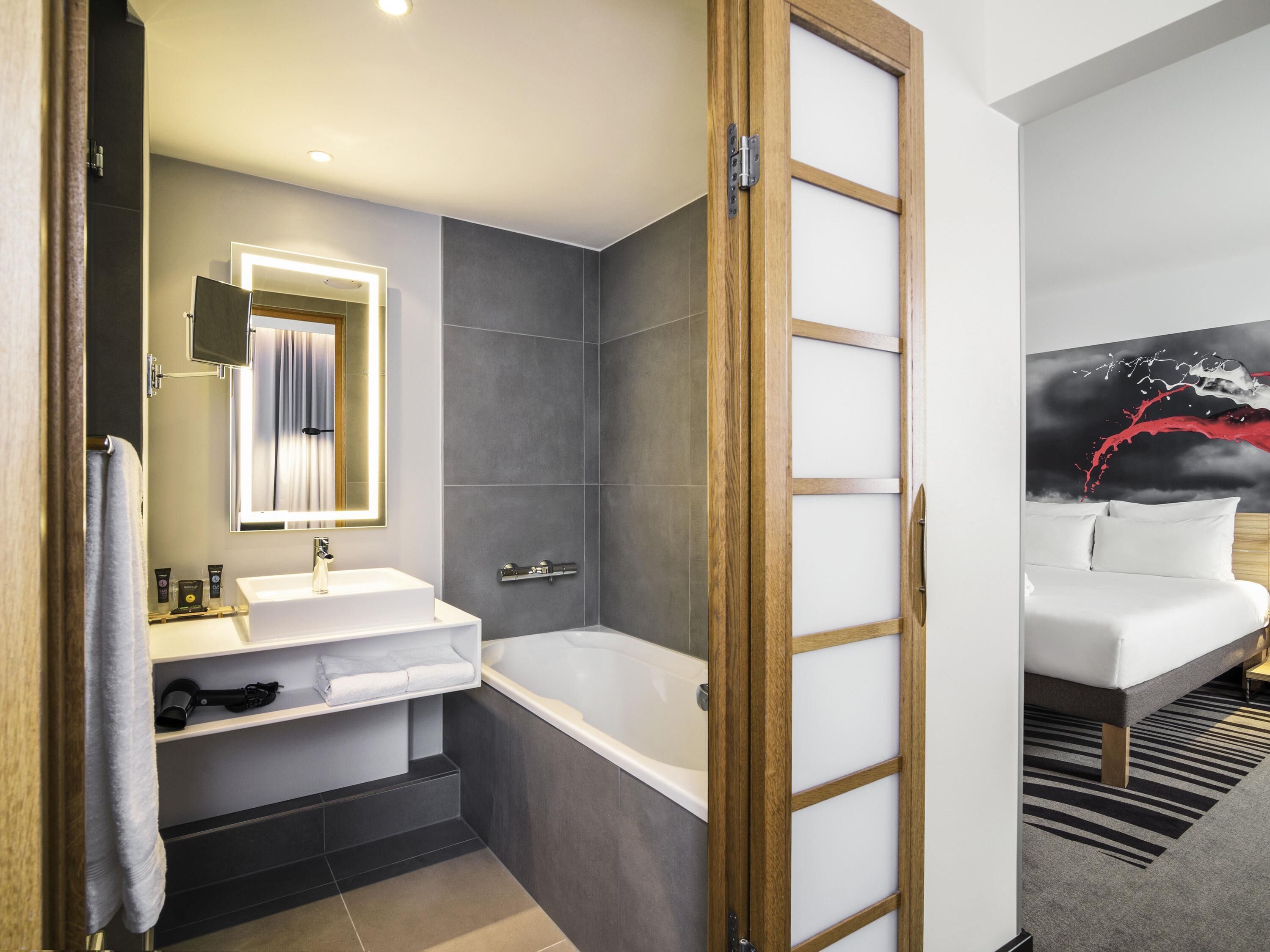 Un bagno moderno con vasca, un mobile lavabo con specchio e zona doccia.