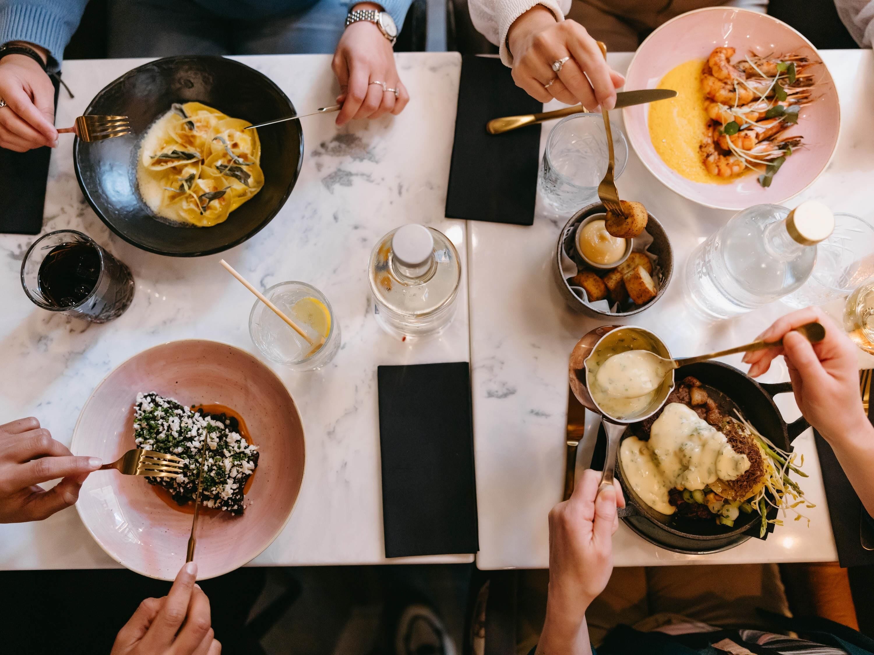 A dining table with various dishes, utensils, and glasses.