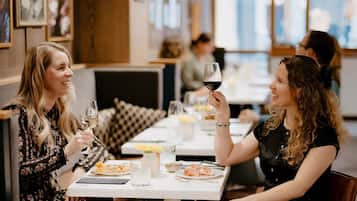 Ein Restaurantinneres mit Tischen, Stühlen und Gästen.