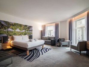 Relax in a stylish room with a large bed, sofa, and unique geometric-patterned mural.