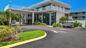Un hotel moderno con entrada cubierta, zona de estacionamiento y cielo despejado.