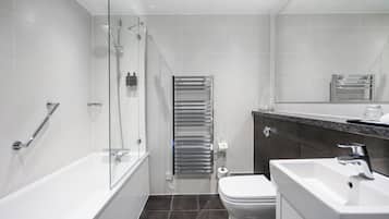Un bagno moderno con doccia vetrata, un water bianco, un lavandino e un porta asciugamani.