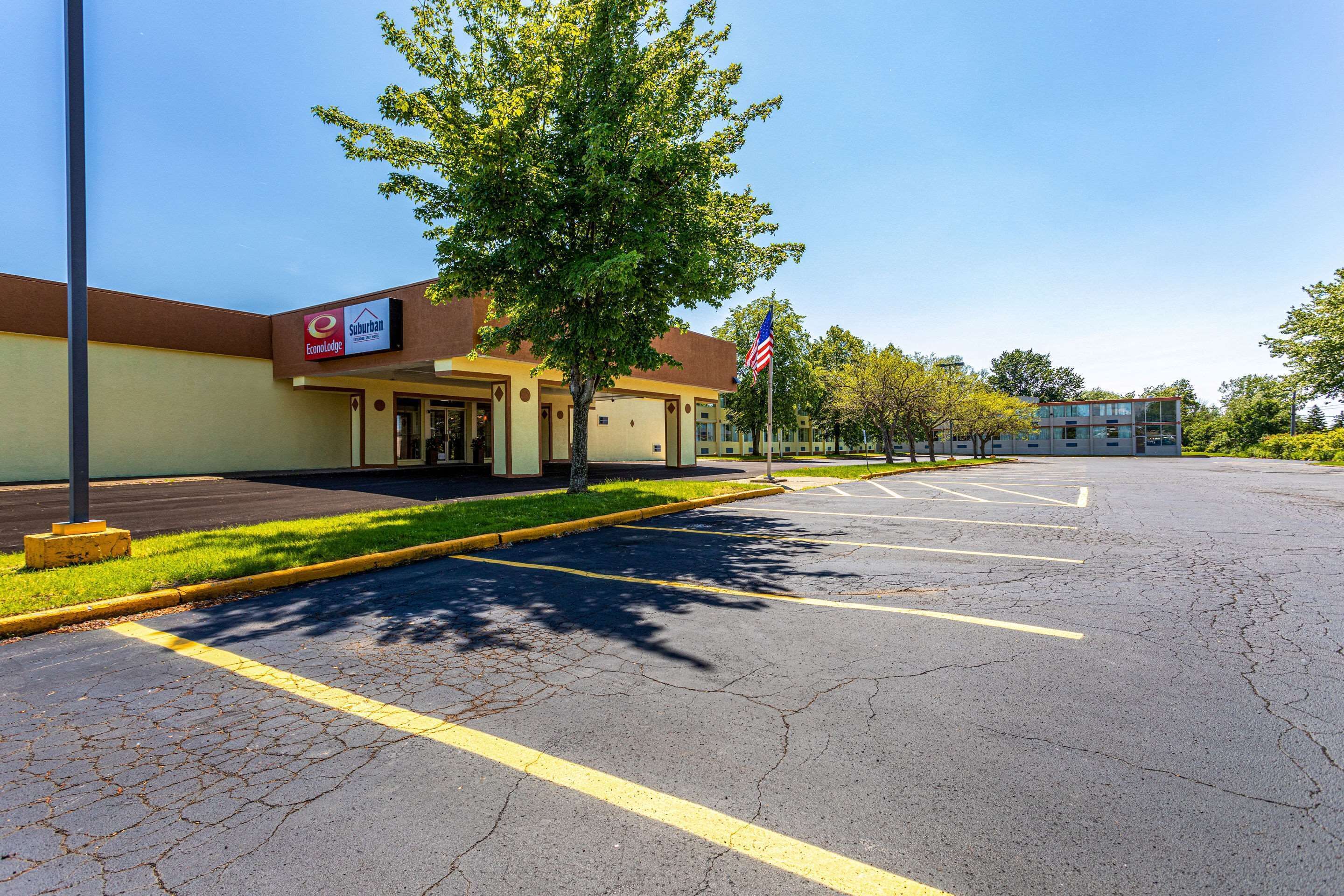 A parking lot with a building labeled "Econ Lodge" and an American flag.