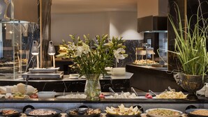 A buffet with various food items and a vase of flowers. - Lake House Kinneret (Tiberias)