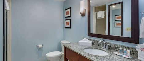 A bathroom with a sink, mirror, and toilet.
