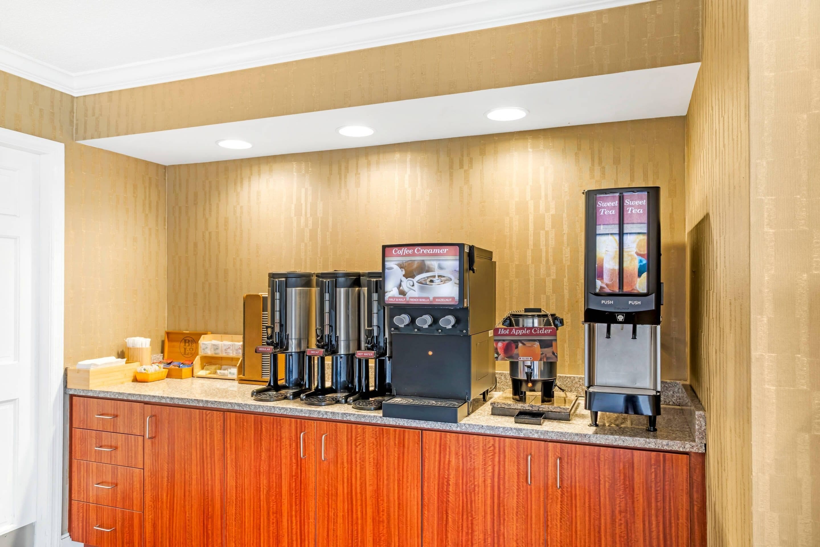 A coffee station with multiple coffee makers and a beverage dispenser.
