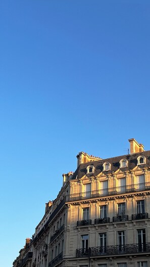 Un immeuble à plusieurs étages, de style architectural classique, doté de balcons richement décorés et de grandes fenêtres.