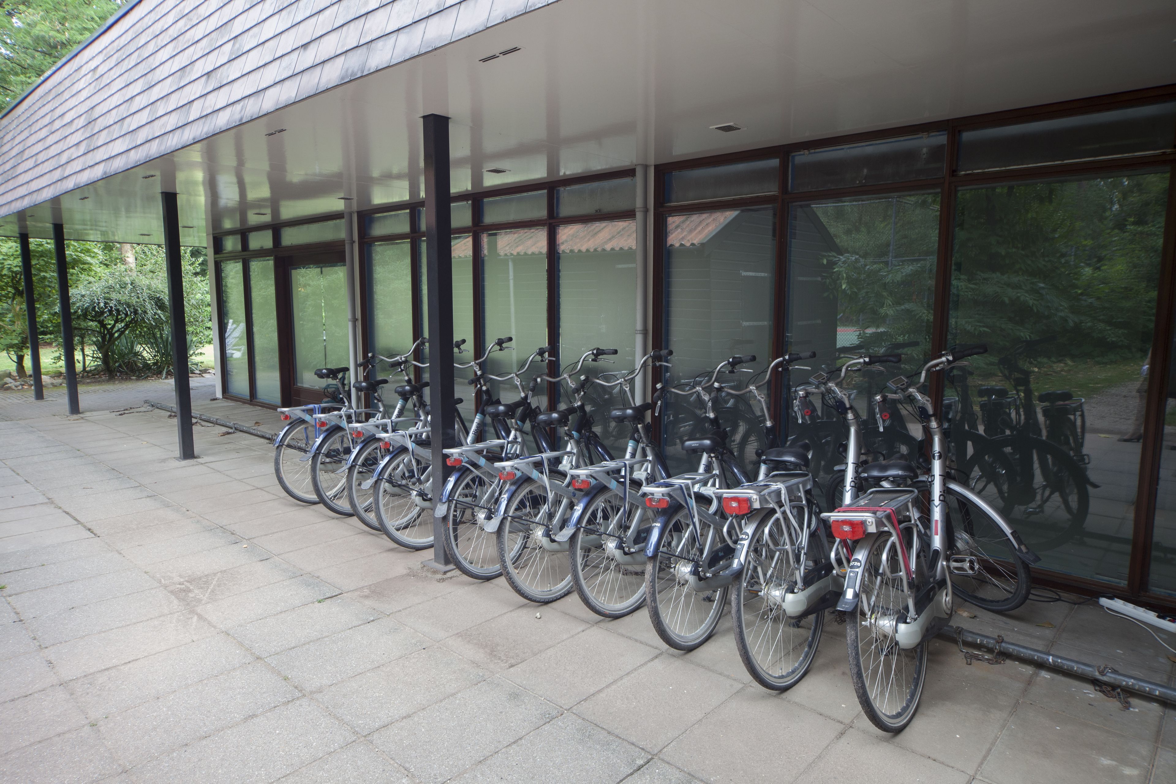 Un área de estacionamiento cubierto para bicicletas con varias bicicletas.