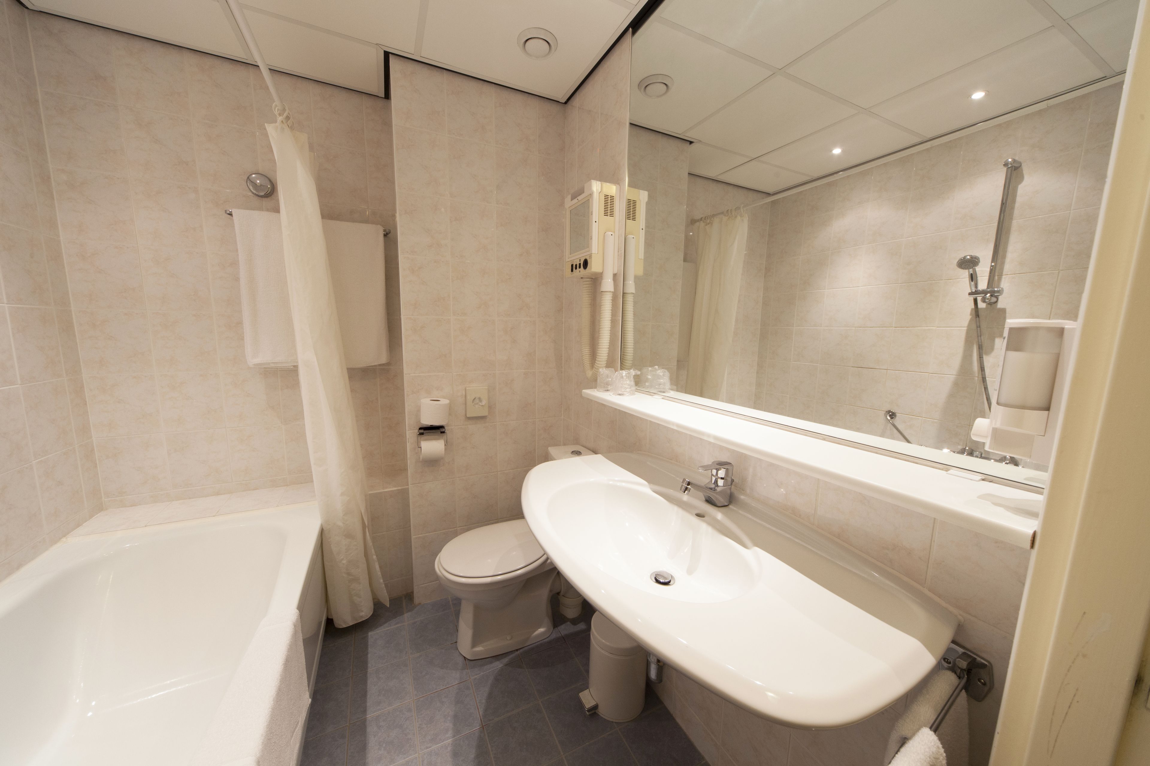 A modern bathroom with a bathtub, toilet, and sink.
