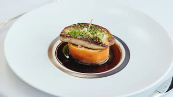 A dessert on a white plate with a glass of wine in the background.