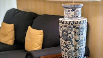 Un vase en céramique bleue et blanche, orné de motifs floraux et de dragons, posé sur une table en bois.