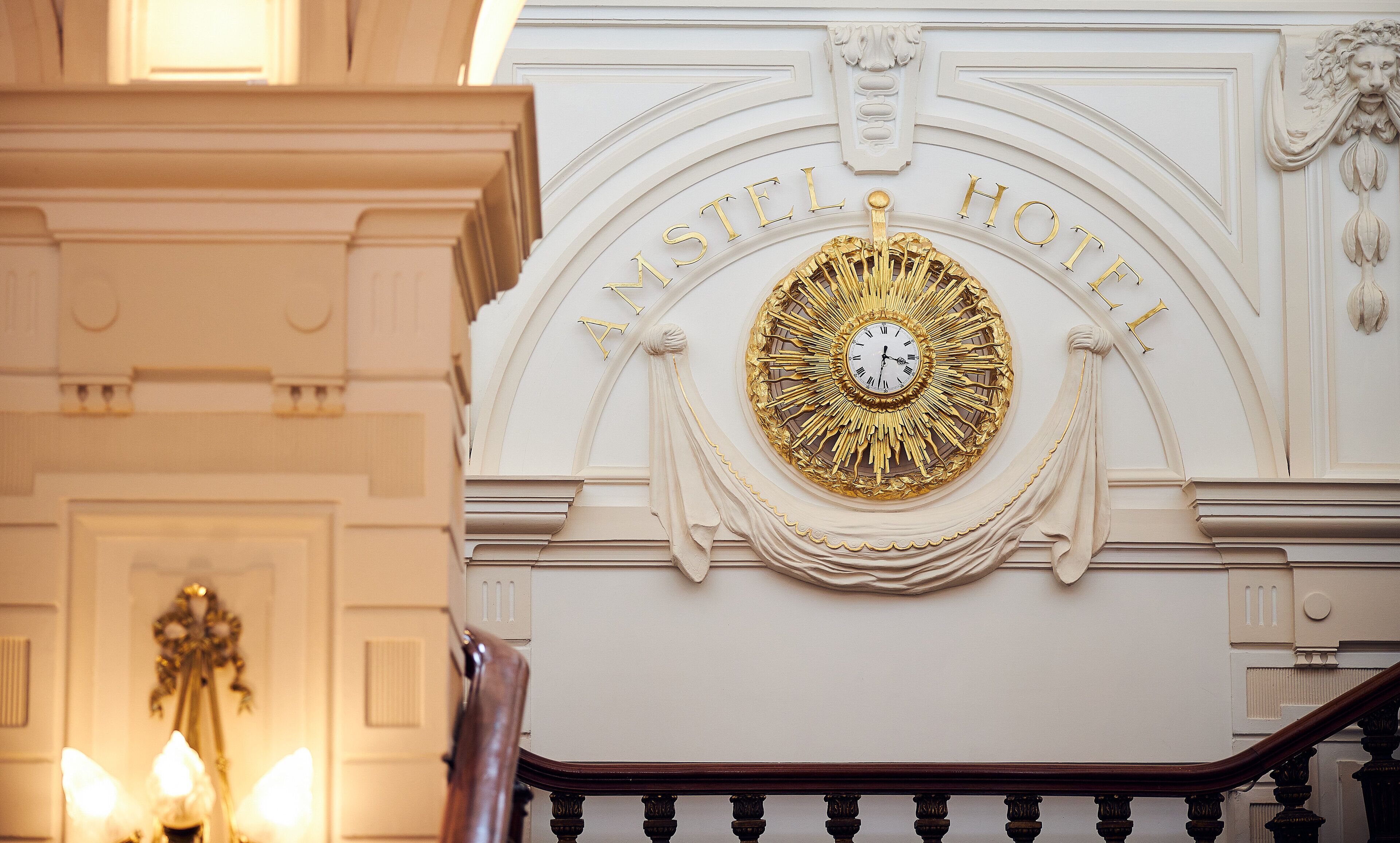 Et imponerende interiør med et stort ur og teksten "ASTEL HOTEL" på væggen.