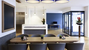 A modern conference room with a long table, chairs, and a white reception desk. - VISIONAPARTMENTS Geneva Gare  (Geneva)