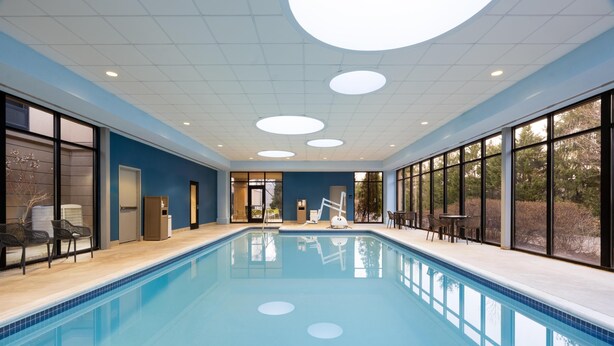 Una piscina con vista al exterior, una puerta y una silla.