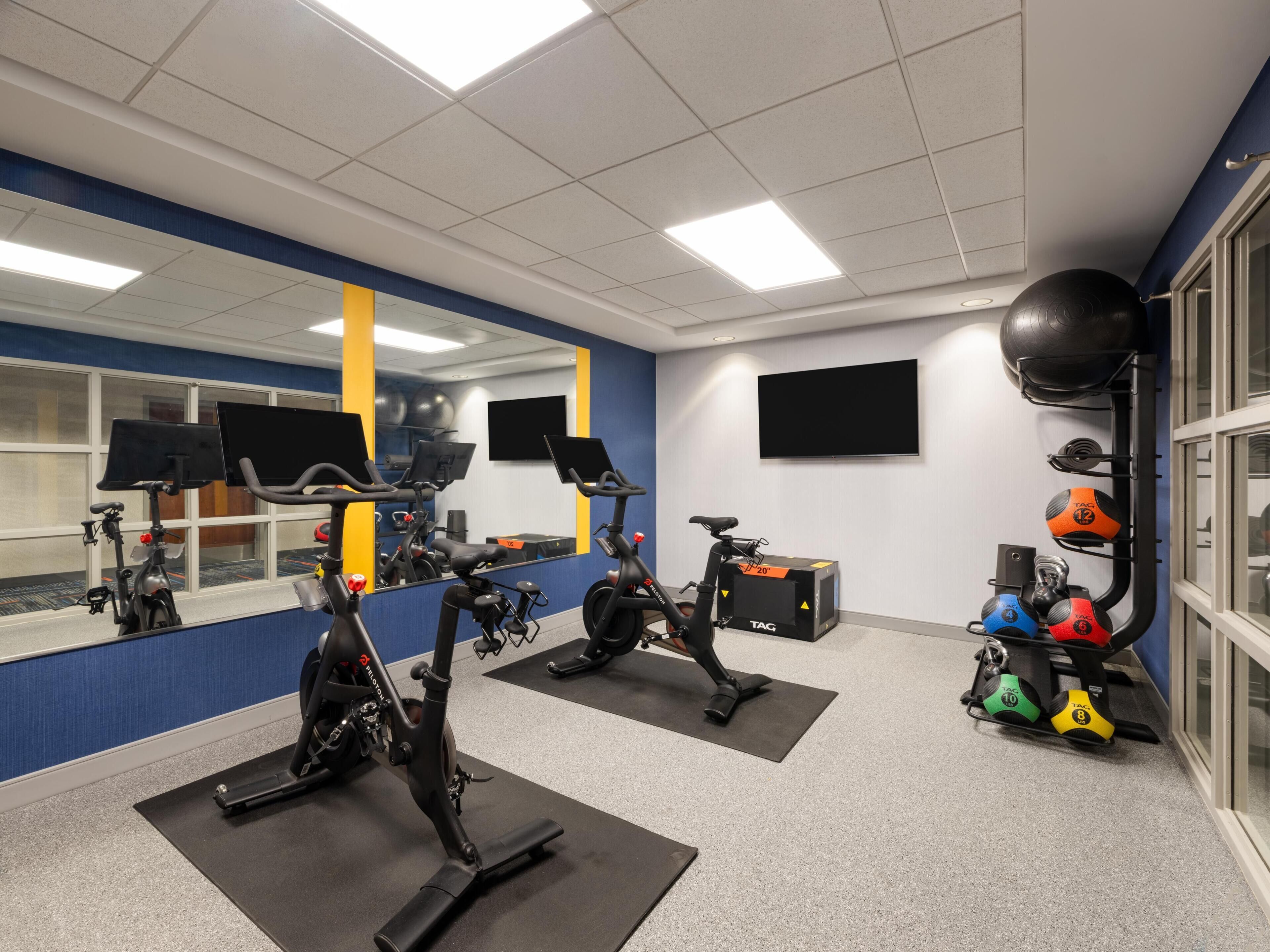 Un gimnasio con bicicletas estáticas, pelotas de ejercicios y kettelbells.