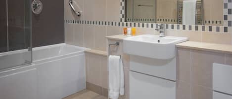 A modern bathroom with a bathtub, a sink, and a mirror.