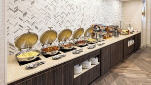A buffet setup with multiple serving stations, including bowls of various foods and utensils. - DoubleTree Suites by Hilton Austin Downtown Capitol (Austin)