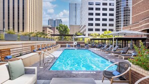 A rooftop pool with lounge chairs, a no diving sign, and a view of surrounding buildings. - DoubleTree Suites by Hilton Austin Downtown Capitol (Austin)