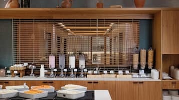A buffet setup with various food items and condiments.