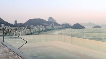 A coastal cityscape with a prominent mountain and a beach.
