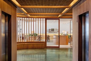 A modern interior with a wooden reception desk, seating area, and a view into the office space. - Othon Palace Copacabana Rio (Rio de Janeiro)