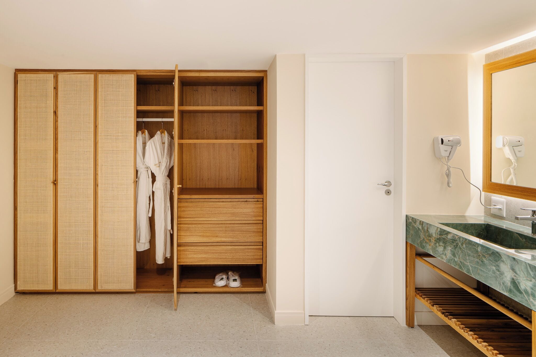 Une salle de bain moderne avec un meuble-lavabo en bois, un grand miroir et un porte-chaussures intégré.