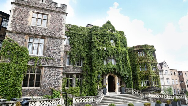 A historic stone building with ivy-covered walls and a grand entrance with steps. - The Abbey Great Malvern (Malvern)