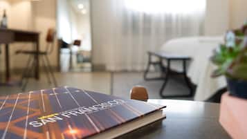 Un livre intitulé « San Francisco » est posé sur une table dans une pièce au décor moderne, comprenant un coin repas et une fenêtre avec des rideaux.