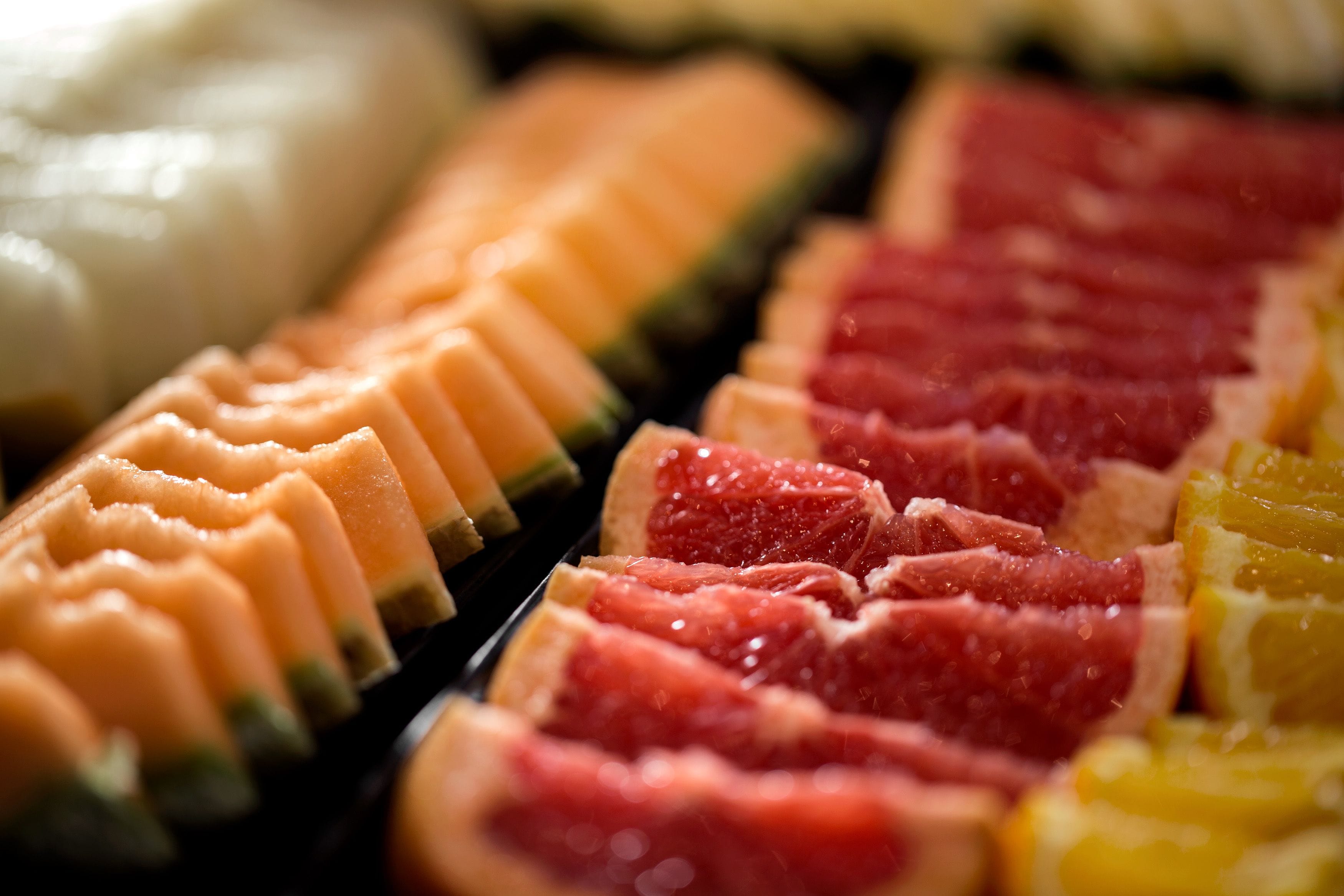 Une vue rapprochée de divers fruits et légumes coupés en différentes formes, probablement dans le cadre d’une présentation culinaire.