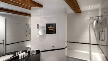 A modern bathroom with a double sink, a bathtub, and a shower. A sign indicates the location as 71 Nyhavn Hotel.