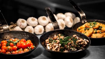 Tres ollas con diferentes alimentos: una con tomates cherry, otra con champiñones y otra con pollo frito.