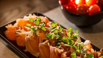 Un plato de salmón decorado con microgreens sobre una fuente rectangular.
