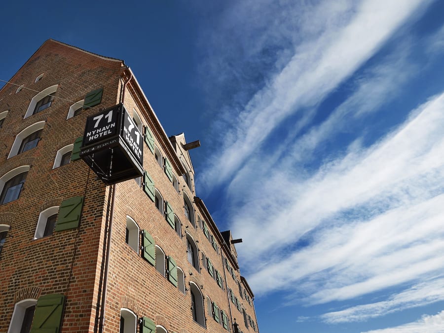 A tall brick building with a sign indicating it is the 71 MyHaven Hotel.