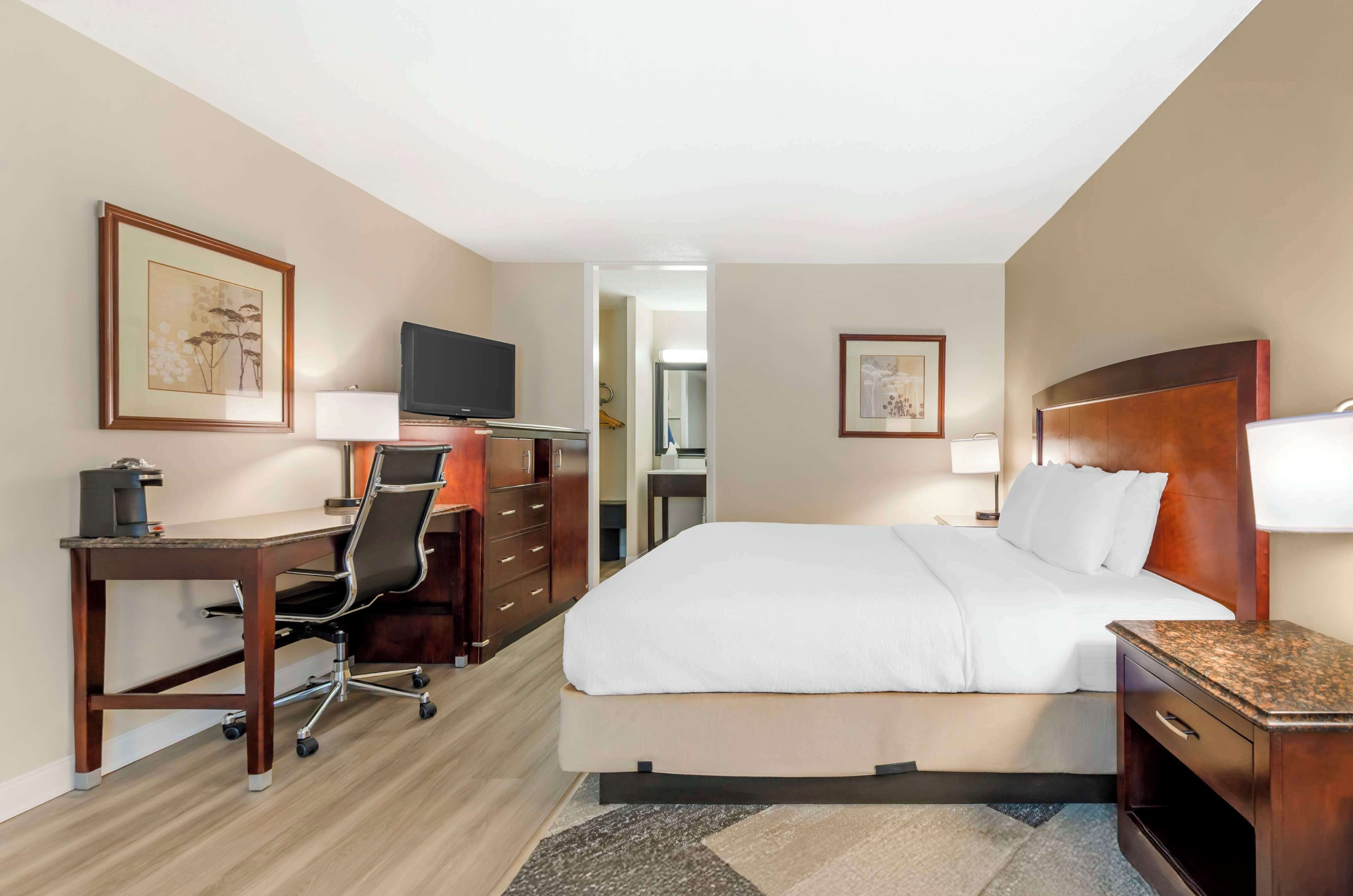 Une chambre d’hôtel équipée d’un lit, d’un bureau, d’une chaise et d’un téléviseur.