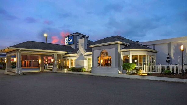 A hotel with a covered entrance, a prominent Best Western sign, and a well-lit facade.