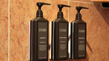 Tre prodotti Gilchrist & Soames: shampoo, balsamo e bagnoschiuma, ognuno etichettato con 'Warm Oak' e una capacità di 12,2 fl oz / 360 ml.