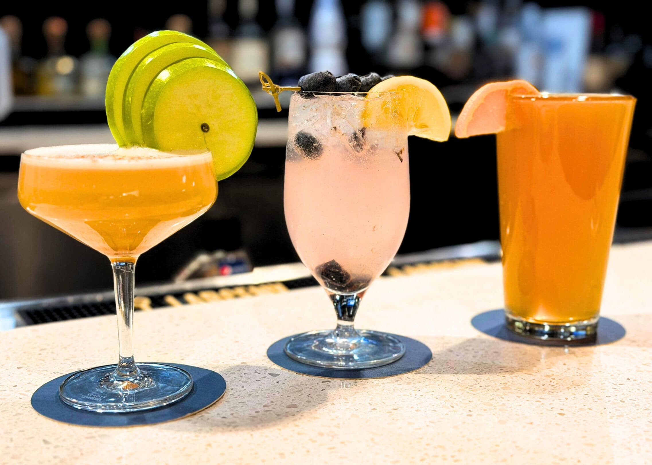 Three different cocktails on a bar counter.
