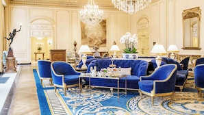 A luxurious lobby with a grand chandelier, plush blue sofas, and ornate decor. - Westgate Hotel (San Diego)